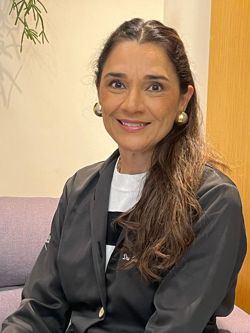 Retrato da Dra. Neliane Teixeira de jaleco escuro